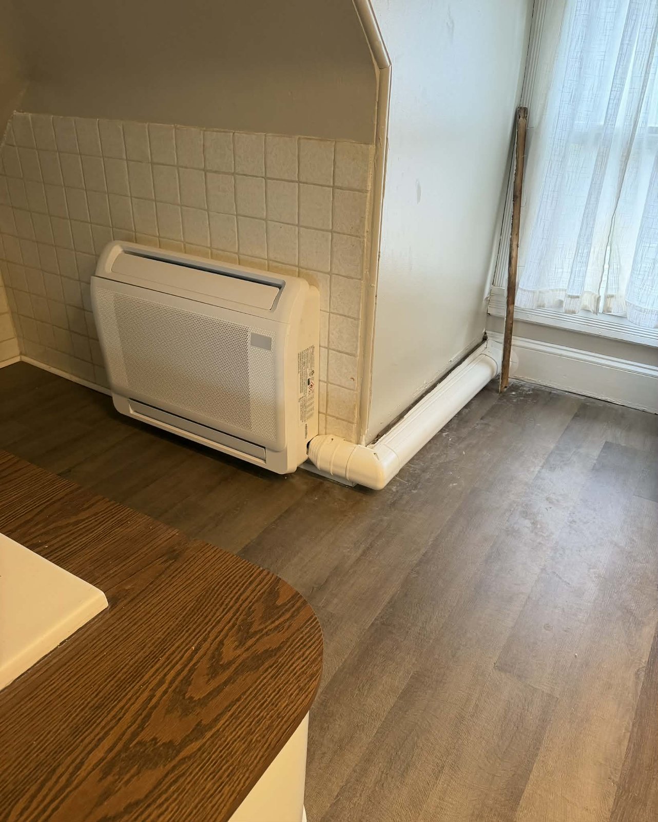 Floor-mounted ductless mini-split indoor console unit installed in a residential room
