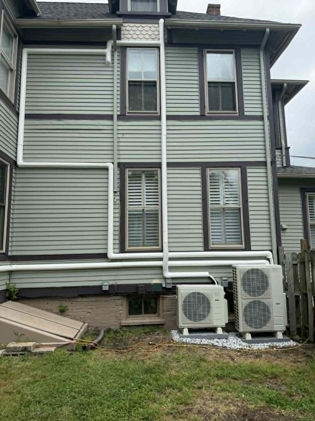 Ductless mini-split heat pump outdoor units neatly installed along a home's exterior wall